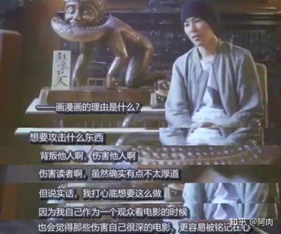 图片为视频截图，画面中一名人物坐在椅子上，背景有一尊造型独特的雕像和写有文字的牌匾。图中显示对话字幕：“画漫画的理由是什么？”以及回答“想要攻击什么东西，背叛他人啊，伤害他人啊，伤害读者啊，虽然确实有点不太厚道，但说实话，我打心底想要这么做，因为我自己作为一个观众看电影的时候，也会觉得那些伤害自己很深的电影，更容易被铭记在心”。整体场景严肃，围绕创作动机展开具有争议性的探讨。