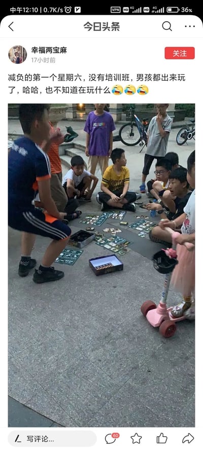 这是一张来自今日头条的社交媒体截图，画面中一群男孩在户外的硬质地面上围坐、聚集，地面铺着多组卡牌游戏的道具，有的男孩盘腿坐着、有的蹲着、有的站着，都将注意力集中在地上的卡牌上，背景中还能看到停放的自行车。配文提到这是减负后的第一个星期六，孩子们不用参加培训班，都出来自由玩耍，整体氛围轻松热闹，展现了孩子们回归户外、享受童年自由玩耍的日常场景。