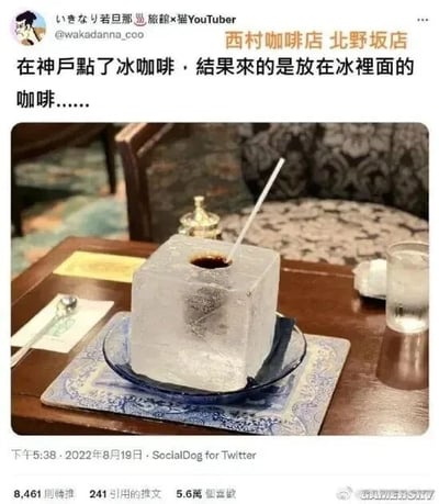 这是一张Twitter（现X）的社交媒体截图，展示了日本神户北野坂西村咖啡店的一款极具创意的冰咖啡。用户点单冰咖啡后，上桌的是一块体积硕大的方形冰块，冰块中心被挖出一个孔洞，孔洞中盛放着黑咖啡，还插有一根白色吸管，冰块被放置在带有花纹的蓝色盘子和餐垫上，旁边还配有一杯清水和餐具。截图上方标注了发布者的账号信息“いきなり若旦那 🏨旅館×猫YouTuber @wakadanna_coo”以及店铺名称“西村咖啡店 北野坂店”，发布者配文吐槽这款冰咖啡的奇特呈现方式：“在神戶點了冰咖啡，結果來的是放在冰裡面的咖啡……”。截图下方显示该内容发布于2022年8月19日下午5:38，由SocialDog for Twitter发布，获得了5.6万点赞、8461次转推和241条引用推文，右下角带有“GAMERSKY”的水印，说明该内容被搬运至国内游戏星空相关平台。