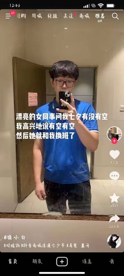 图片为抖音视频截图，内容是一名穿蓝色POLO衫的男子在镜子前自拍。画面上方有文字描述：漂亮的女同事问自己七夕是否有空，自己高兴地答应后，对方却提出换班的请求。通过日常职场场景中的反差感制造幽默效果，展现了七夕节期间打工人的无奈与搞笑经历。