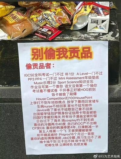 这是一张摆放在零食祭品下方的手写风格打印告示，标题为“别偷我贡品”，下方罗列了一长串针对偷贡品者的“诅咒”内容。这些诅咒精准命中了国际课程学生的考试失利痛点、校园生活的各类倒霉事、二次元爱好者的糟心经历以及游戏玩家的不顺体验，用年轻人熟悉的场景制造出搞笑又硬核的效果，充满共鸣感。