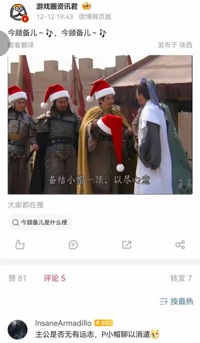 微博用户“游戏圈资讯君”发布的一张搞笑梗图，将三国历史人物与圣诞节元素结合。图中几位身穿古装铠甲的三国人物戴着红色圣诞帽，中间人物手持圣诞帽，配文“备结小帽一顶，以尽心意”，玩了刘备（字玄德）名字的谐音梗。图片上方有“今顾备儿～♪，今顾备儿～♪”的文字，结合了“刘备”与“圣诞快乐”的谐音，营造出幽默的节日氛围。