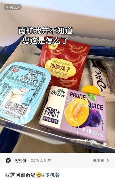 这是一张乘客拍摄的中国南方航空航班飞机餐实拍图，餐盒内的食品搭配十分有反差感，包含光明原味风味酸牛奶、油泼辣子调味包、100%果汁含量的碧林西梅汁、德芙巧克力。图上方配文“南航我并不知道您这是怎么了”，图下方配文“我就问谁敢喝😆#飞机餐”，图片底部是社交平台的飞机餐话题入口，显示有3.7万人参与该话题讨论。西梅汁本身有促进排便的功效，搭配刺激性的油泼辣子，网友调侃食用该份餐食后可能出现肠胃不适，对应了标题“活着下不了飞机”的玩笑梗。
