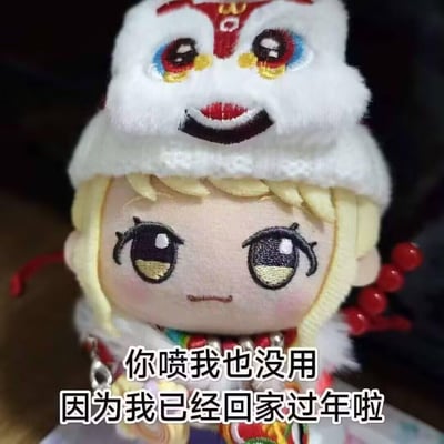 这是一张充满新年氛围的可爱梗图，主体是一个有着金色头发、刺绣大眼睛的软萌棉花娃娃，娃娃戴着带有醒狮造型的白色针织帽，脸颊带着淡淡的红晕，表情平静中带着一丝小傲娇。图下方配有文字：“你喷我也没用 因为我已经回家过年啦”，用可爱的方式表达自己已经放假回家，无需再理会工作中的指责或烦心事，传递出放假后的轻松与得意，非常贴合新年放假的心情。