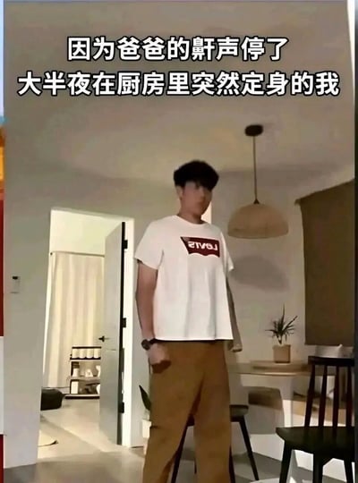 这是一张引发大众共鸣的生活类梗图，图中一名年轻男性站在住宅的餐厅区域一动不动定在原地，配文为“因为爸爸的鼾声停了，大半夜在厨房里突然定身的我”，内容还原了很多人和父母同住时，半夜偷偷起来活动，本来以为爸爸已经熟睡，结果原本持续的鼾声突然停止，当事人立刻吓得不敢动弹，生怕被爸爸发现自己偷偷出来的真实经历，十分有代入感，戳中了很多人的共同体验。