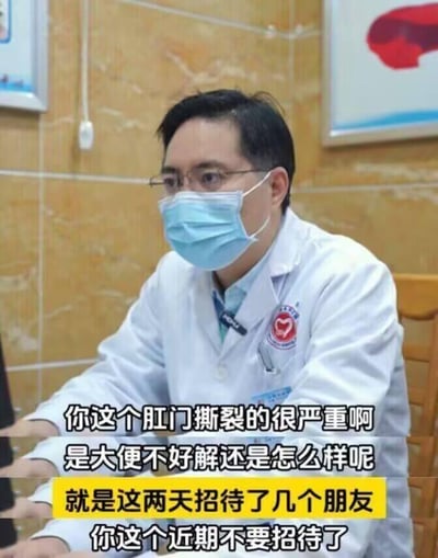 这是一张呈现医院问诊场景的搞笑梗图，画面中是一位身着白大褂、佩戴口罩和眼镜的男医生，坐在诊室里。图中通过添加字幕构建了趣味对话：医生先询问患者肛门撕裂严重的原因，患者称是因为这两天招待了几个朋友，医生随即叮嘱患者近期不要招待朋友。这个梗的笑点在于利用“招待朋友”的字面含义和实际引发病情的原因（招待朋友时的不当饮食导致便秘进而引发肛门撕裂）形成反差，医生的叮嘱看似禁止社交，实则是提醒患者注意饮食，避免病情加重，用生活化的幽默方式调侃了社交应酬引发健康问题的情况。