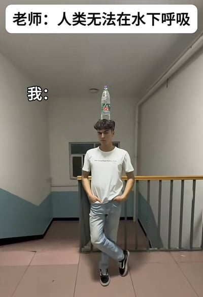这是一张竖版搞笑网络梗图，拍摄场景为居民楼或宿舍楼的楼道转角，墙面下半部分为蓝绿色、上半部分为白色，后方可见楼梯栏杆。顶部白色圆角框内配文“老师：人类无法在水下呼吸”，画面左侧标注“我：”，主体是一位穿着白色短袖、浅蓝色牛仔裤、黑白色帆布鞋的年轻男子，他双手插在裤兜、双腿交叉站立，面无表情看向镜头，头顶平稳放着一瓶装满水的矿泉水，用“头顶有一瓶水就相当于身处水下”的荒谬抬杠逻辑曲解老师的表述，制造出无厘头的搞笑效果。