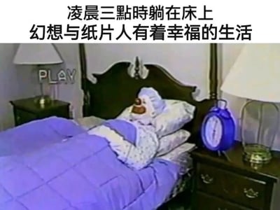 这是一张带有自嘲意味的搞笑梗图，画面呈现复古录像带风格：一位戴着小丑头套的人物躺在床上，盖着紫色被子，靠在枕头上，床头右侧的蓝色闹钟显示时间为凌晨三点，画面左上角有“PLAY”的录像带标识。图上方配有文字“凌晨三点时躺在床上 幻想与纸片人有着幸福的生活”，精准戳中了许多二次元爱好者深夜难以入眠，沉浸在与自己喜爱的虚拟（纸片人）角色的幻想生活里的状态，用小丑的形象自嘲这种私密又有点“中二”的深夜情绪，既幽默又能引发同好的强烈共鸣。