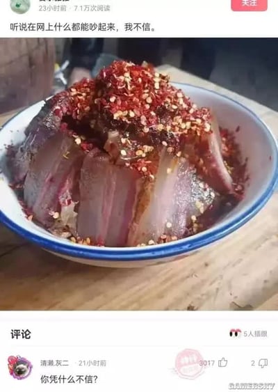 这是一张社交平台帖子截图，顶部是发帖用户的内容，配文“听说在网上什么都能吵起来，我不信”，配图是一碗盛在蓝边白瓷碗里、表面铺满大量红辣椒面的腊味肉食，放置在木质桌面上。下方评论区第一条高赞评论为用户“清濑.灰二”发布的“你凭什么不信？”，这条抬杠式的回复刚好印证了“网上什么都能吵起来”的说法，形成强烈的反差笑点，讽刺了互联网上部分网民喜欢无故抬杠、无论什么内容都能引发争执的现象。