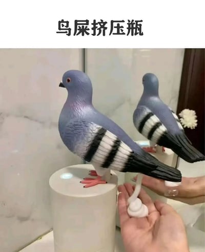 图片展示了一款创意整蛊玩具——鸽子造型的“鸟屎挤压瓶”。画面中有两个鸽子形态的挤压瓶，主体为灰色，翅膀带有黑白相间的条纹，眼睛呈红色，脚爪为橙色。左侧的鸽子玩具站立在一个白色圆柱形底座上，右侧的鸽子玩具被一只手握住，底座连接着一个白色的挤压装置。图片顶部配有文字“鸟屎挤压瓶”，清晰点明产品名称。该玩具设计模仿真实鸽子，通过挤压瓶身可模拟挤出“鸟屎”状物质，用于恶作剧或趣味互动。