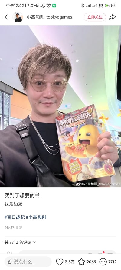 社交媒体截图中，用户小高和刚_tookyogames在室内环境（疑似商场或书店）自拍，手持一本封面印有黄色卡通角色“奶龙”的彩色书籍《家有奶龙乐翻天》。配文“买到了想要的书！我是奶龙”，并带有#百日战纪 #小高和刚话题标签。截图显示发布时间为08-27 日本，互动数据包括3.5万点赞、2069收藏和7712条评论。