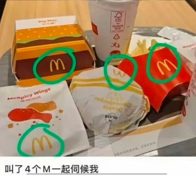 这是一张麦当劳餐品的实拍图，画面里包含巨无霸包装盒、薯条盒、麦辣鸡翅包装以及一个双层芝士汉堡的包装，四个包装上的麦当劳金色M标志都被绿色圆圈标注出来，图片底部配文“叫了4个M一起伺候我”。
玩了谐音梗：将麦当劳的品牌标识M，和网络语境里的“MM”（指代服务型角色）结合，用幽默的口吻调侃自己点了多份麦当劳餐品，仿佛有四个“M”来“伺候”自己，制造出趣味反差感。