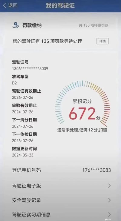 这是一张驾驶证电子信息页的截图恶搞图，画面显示驾驶证累计计分高达672分，且有135项罚款尚未处理，配合界面提示“违法未处理，记满12分，扣留”，形成强烈反差和幽默感。通过数据夸张表达车主违规严重，常被用来调侃“开车太猛”或“马路杀手”。没有明显谐音或双关，但以荒诞数值表达网络恶搞。