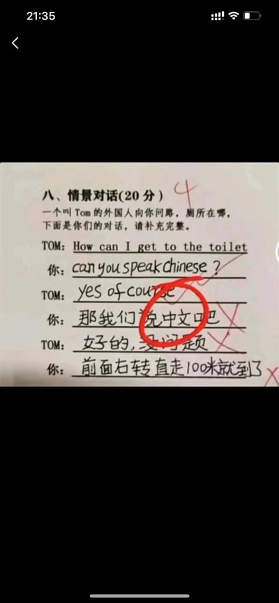 这是一张学生英语情景对话作业的翻拍图，题目设定为外国友人Tom用英文询问厕所在哪里，要求补充英文对话内容。但答题的学生没有按照题目要求用英文作答，反而先询问Tom是否会说中文，在得到肯定答复后提议切换中文交流，还在Tom的台词里将“好的”错写成“女子的”，所有中文回答都被老师打叉批改，整个对话完全偏离了英语答题的要求，呈现出答非所问又带有错别字的搞笑效果，是典型的趣味学生作业案例。