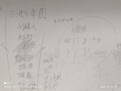 这是一张拍摄于2024年4月5日的墙面涂鸦照片，内容围绕国内男子组合时代少年团展开：
1. 左侧写有“时代少年团”字样，下方列出成员刘耀文、宋亚轩、王一浩（被涂黑）、张真源、丁程鑫、贺峻霖的名字；
2. 右上方有“王❤️宁❤️张”的字样；
3. 右侧画有一个对话气泡，里面写着“时代少年团 YYDS”，旁边还有小气泡写“没实力!!!”；
4. 还有手写的“马戏团 拉爆了！”“马戏团 没实力”的负面评价内容，明显是粉丝和黑粉在墙面上的留言对抗，没有双关或谐音梗。