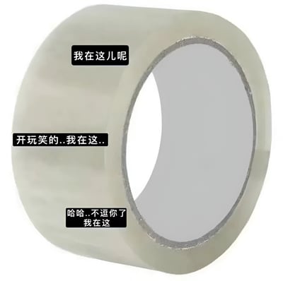 图片主体是一卷透明胶带，胶带表面从上到下分布着三个黑色文本框，分别写着“我在这儿呢”“开玩笑的...我在这...”“哈哈..不逗你了 我在这”。文本以俏皮的语气模拟胶带“捉迷藏”的场景，通过多次“谎报位置”制造出幽默搞笑的效果，仿佛胶带在和观看者互动开玩笑。