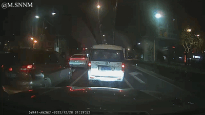 这是一张行车记录仪拍摄的夜晚城市道路画面，画面中多辆汽车在道路上排队行驶，前方车辆的尾灯亮起，道路两旁有路灯和建筑物，整体呈现出夜间城市交通的日常拥堵场景，画面左下角带有行车记录仪的设备标识与拍摄时间戳，左上角有用户水印。