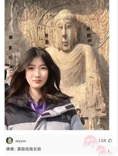 这是一张充满趣味的视觉错位实拍图，一位长发女生在石窟佛像前面对镜头拍照，由于拍摄角度的巧合，女生的脸与佛像的位置完美重叠，视觉上仿佛佛像拥有了女生的脸，形成了荒诞又搞笑的效果。背景中可以看到其他游客在拍摄佛像，场景是典型的旅游景点。下方的社交媒体评论区里，用户ssyyxx的评论“佛像：真能给我长脸”获得1.3万点赞，该评论运用双关语，既对应了照片中脸重叠的视觉现象，又借用“长脸”的引申义（争光、有面子）制造出幽默的梗，让这张错位照的趣味性进一步提升。