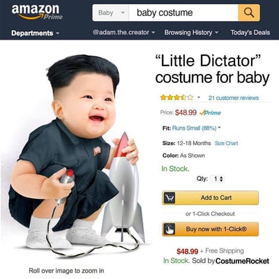 这是一张模仿亚马逊Prime商品页面的图片，展示了一款名为“Little Dictator”（小独裁者）的婴儿服装。页面左侧是一个穿着深色制服的婴儿，制服上有类似徽章的装饰，婴儿手持一个玩具火箭和遥控器，面带笑容。右侧是商品信息区域，包括价格（$48.99）、评分（4.5星，21条评论）、尺寸（12-18个月）等信息，以及“加入购物车”和“一键购买”按钮。图片明显带有政治讽刺意味，通过将婴儿服装与独裁者形象联系起来制造争议效果。