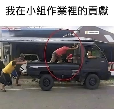 图片上方有文字'我在小组作业裡的貢獻'，下方是一张实景照片：几名男子正在路边合力推动一辆黑色卡车，车旁有人在用力推车，而一名穿红色上衣的男子却正攀爬进入卡车后斗，其动作被红色圆圈重点标注。通过对比推车者的卖力与红衣男子的'划水'行为，幽默地比喻自己在小组作业中几乎没有实质贡献，像那个看似参与实则未出力的角色。