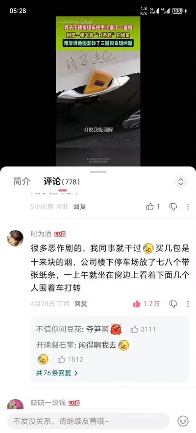 这是一张手机屏幕截图，内容分为上下两部分：上半部分是B站短视频内容，顶部绿色背景配文说明事件：男子下楼发现车把手被塞了一盒烟，还附带一张写着“对不起”的纸条，车主难受得围着车找了三圈都没发现问题，画面展示了塞在车把上的烟和写有“对不起”的纸条，视频还配有字幕“咱说我能理解”；下半部分是该视频的B站评论区，热评第一是用户“时为酒”分享自己同事做同类恶作剧的经历，称同事买廉价烟给停车场七八辆车都放了带纸条的烟，一上午坐窗边看车主围着车打转，该评论获1.2万点赞，下方还有其他网友调侃“太损”“太闲”的回复，评论区底部还有输入框提示“不发没关系，请继续友善哦~”。