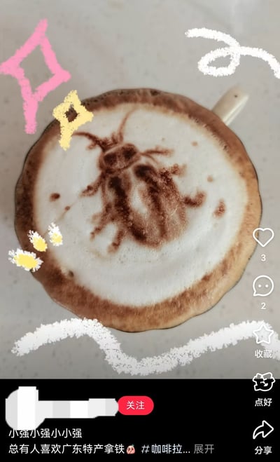 图片主体是一杯拿铁咖啡，奶泡表面用拉花工艺绘制了一只蟑螂形象，其超长触角形似“广式双马尾”梗中的双马尾造型。咖啡杯周围有粉色菱形、黄色星形及白色波浪线等装饰性涂鸦，底部配有文字“总有人喜欢广东特产拿铁 😂 #咖啡拉花...展开”。整体通过将地域特色梗与日常饮品结合，营造出荒诞又搞笑的氛围，是对“广式双马尾”热梗的创意衍生。