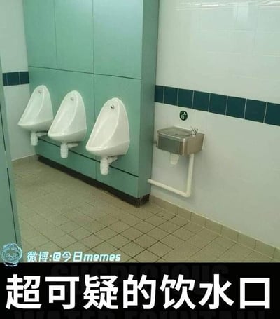 这张图拍摄的是男性公共卫生间内部，墙角隔柱上整齐安装了三个白色壁挂式小便池，而紧挨着隔柱的卫生间墙面上，错误地安装了一个公共直饮水装置，直饮水口位置靠近小便池，外观和位置很容易引发不良联想，图片底部配有醒目的白色大字文字“超可疑的饮水口”，左下角标注了中文传播来源“微博:@今日memes”，是一张吐槽尴尬设计失误的搞笑梗图。