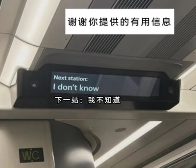 这是一张在地铁车厢内拍摄的实拍照片，画面核心是车厢顶部的电子报站显示屏，因系统故障，屏幕上的英文报站内容显示为“Next station: I don't know”，下方还配有对应的中文翻译“下一站：我不知道”，完全无法为乘客提供有效的站点信息。显示屏上方被添加了一行吐槽文字“谢谢你提供的有用信息”，用反讽的语气调侃这一毫无用处的故障报站内容，放大了场景的荒诞感。画面左下角还能看到带有“WC”标识的卫生间指示牌，进一步确认了这是地铁车厢内的场景。整体画面将公共交通系统的故障转化为搞笑的素材，充满了趣味性。