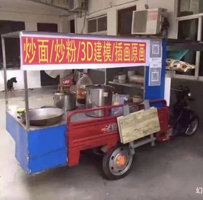 这是一张充满反差感的网络梗图，主体是一辆由红色电动三轮车改装的小吃摊，摊位操作台为蓝色，摆放着炒面用的锅具、不锈钢容器等小吃制作设备，摊位上方的红色招牌用醒目的黄色字体写着“炒面/炒粉/3D建模/插画原画”，将街头常见的小吃服务与专业的设计类服务并列，形成强烈的违和感与幽默感。背景是一个简陋的室内或半封闭场地，远处还有一只黑狗安静站立。这张图是对设计行业从业者生存现状的自嘲式调侃，暗喻在行业内卷、收入压力下，从业者不得不兼顾副业，甚至将专业技能也当作“摆摊项目”，引发职场打工人的共情。