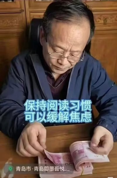 图片中一位中年男性正坐在木质家具前专注地数着人民币，他戴着眼镜，神情认真，双手正在整理一沓百元纸币。图片中央有一行蓝色文字："保持阅读习惯可以缓解焦虑"，形成了数钱动作与文字内容的幽默对比，暗示了一种调侃式的"缓解焦虑"方式。