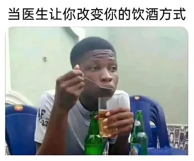 图片上方有文字“当医生让你改变你的饮酒方式”，下方是一名男子正用勺子从酒杯中舀取液体饮用的场景。男子面前放有绿色啤酒瓶，他一手持酒杯，一手拿勺子，表情专注。图片通过幽默的方式调侃了人们对“改变饮酒方式”的曲解——不是减少饮酒量，而是用勺子这种奇特的方式饮用。