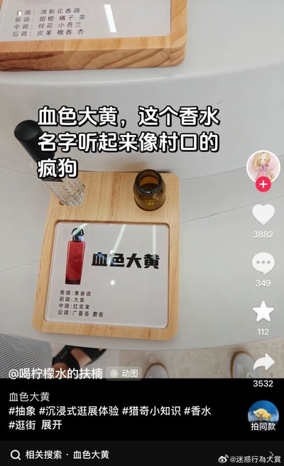 这是一张社交媒体动态截图，主体是线下展示的一款名为“血色大黄”的香水展品，木质展架上的说明卡标注这款香水为果香调，前调为大黄、中调为红浆果、后调为广藿香和麝香。图片上方叠加了配文吐槽“血色大黄，这个香水名字听起来像村口的疯狗”。截图保留了平台的交互按钮及数据，点赞数3882、评论数349、收藏数112、转发数3532，底部显示发布者为@喝柠檬水的扶楠，附带#抽象 #沉浸式逛展体验 #猎奇小知识 #香水 #逛街等话题标签，右下角带有@迷惑行为大赏的水印，底部还有“血色大黄”的相关搜索入口。