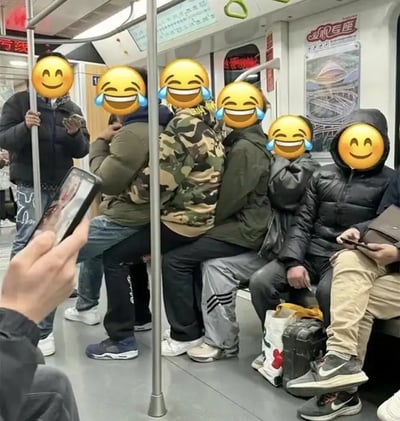 这张图片拍摄于地铁车厢内，画面中四位男子坐在地铁座位上，另两名男子则分别坐在他们的大腿上，现场排成一排，看起来十分滑稽。所有人的脸部都被带泪笑哭的表情包/表情符号遮挡，增添了浓厚的喜剧和网络梗氛围。画面左侧还可见一人用手机拍照，仿佛在记录这搞笑的一刻。这种“错位”坐法和表情处理手法注重表现生活中随性幽默和朋友间的欢乐氛围。

双关/谐音梗提示：此图通过“错位乘坐”制造出幽默冲突感，并用笑哭表情强化了搞笑效果。