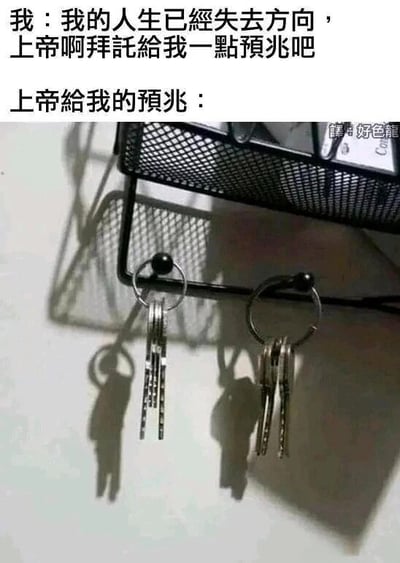 这是一张图文混排的搞笑梗图，上方文字分为两部分，第一部分是“我：我的人生已经失去方向，上帝啊拜托给我一点预兆吧”，表达了一个人在迷茫时向上帝祈求指引的心情；第二部分是“上帝给我的预兆：”，引出下方的图片内容。下方图片是挂在黑色架子上的两串钥匙，在光线照射下，钥匙和钥匙环的影子投射在墙面上，形成了两个类似弯腰前行的人形，看起来像是奔波的打工人。这张图用视觉错位的效果制造了搞笑的梗，暗示上帝给出的“预兆”是让“我”继续像打工人一样埋头工作，用幽默的方式调侃当代人被工作裹挟的无奈处境。