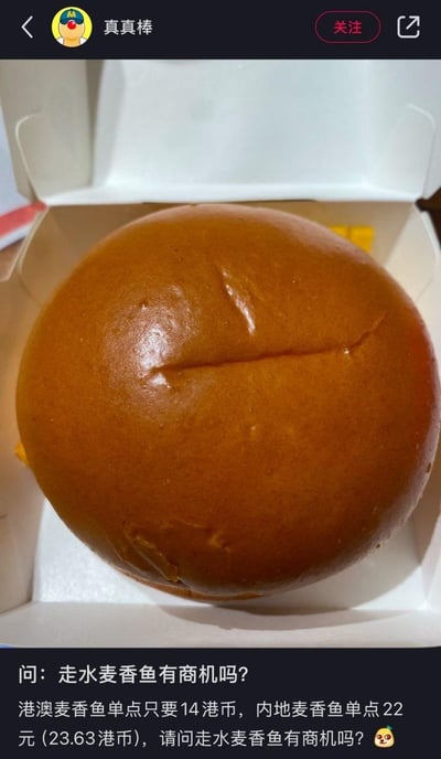 这是一张竖屏格式的社交媒体截图，上方是装在包装盒里的麦当劳麦香鱼汉堡实拍图，下方配文提出一个带有调侃性质的问题：“走水麦香鱼有商机吗？”，同时对比了港澳地区与内地麦香鱼的单点价格：港澳仅需14港币，内地则为22元人民币（约23.63港币），通过两地的价格差，玩笑式地探讨是否可以通过“走水”（对带货、跨境私带的戏称）来获取商机，内容充满趣味性与话题性。