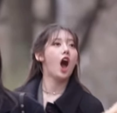 图片展示了一位长发女生，身穿黑色外套，脖颈上佩戴着一条精致的项链，从画面来看应是在户外场景，背景有些模糊，人物服装偏休闲时尚，适合日常出行。整体画风自然贴近日常生活，没有明显双关或谐音梗，也无搞笑、暗示等元素。图片可以用于表达日常出行、春秋穿搭等氛围。