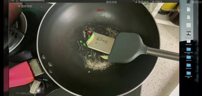 这是一张硬件爱好者创作的恶搞整活截图，画面主体为一口放置在燃气灶上的黑色不粘炒锅，锅内放有一块AMD EPYC系列服务器处理器，旁边搭配了葱花、姜片、小米辣等家常炒菜配料，还有一把硅胶锅铲搭在处理器旁，模仿煎炒食材的场景，调侃CPU发热量大的特性。画面叠加了多条来自图拉丁吧相关社群的弹幕，右侧露出电脑桌面的侧边栏，说明该图是电脑屏幕的直播或视频截图，左下角显示有9000+人正在观看该内容。