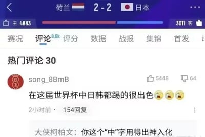 这是一张体育赛事平台的世界杯比赛评论区截图，顶部显示荷兰对阵日本的比分为2比2，页面处于评论标签页下。热门第一条评论称“在这届世界杯中日韩都踢的很出色”，附带三个捂嘴笑的表情，获得5448次点赞，下方有用户回复调侃这条评论里的“中”字用得出神入化，玩了中国男足未晋级该届世界杯的相关梗，带有讽刺调侃的意味，是球迷圈层传播的趣味玩梗内容。