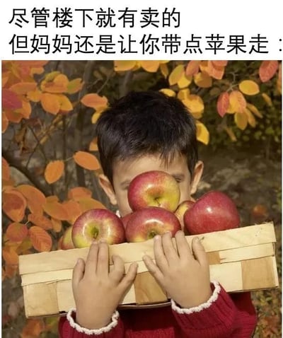 这是一张图文混排的静态图，上方配有文字“尽管楼下就有卖的，但妈妈还是让你带点苹果走：”，图中主体是一个穿着红色毛衣的小孩，双手捧着一个装满红苹果的浅木筐，筐里的苹果个头饱满、色泽红润，几乎挡住了小孩的整张脸，背景是带有橙黄色叶子的树枝，营造出秋日的温暖氛围。这张图用画面呼应文字，精准捕捉了亲情里常见的暖心细节：即便外面可以买到同样的东西，家人还是想把自己准备的物品塞给孩子，这份朴实的举动满是浓厚的关爱，很容易引发大众对家人关爱的共鸣。