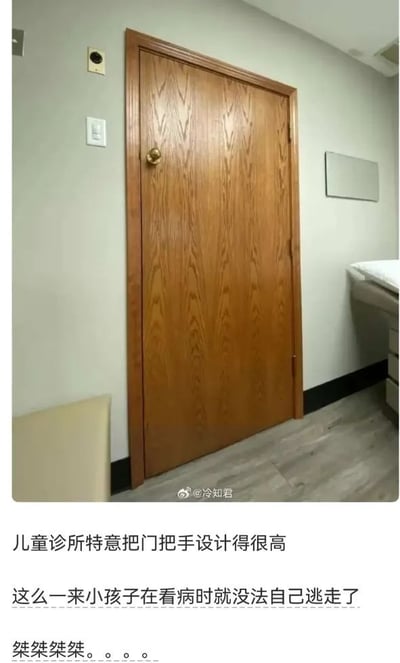 这张图文混排的趣味梗图上半部分是实拍的室内场景：浅灰色墙面旁立着一扇带有实木纹路的棕色房门，门把手被设置在门板非常高的位置，靠近门板上沿，墙面旁可以看到开关、感应装置，右侧露出诊疗床的边角，地面为仿木纹理地板。图片下方配文依次为“儿童诊所特意把门把手设计得很高”“这么一来小孩子在看病时就没法自己逃走了”，末尾搭配了一串类似反派笑声的“桀桀桀桀。。。。”，用脑洞大开的搞笑解读调侃诊所的设计巧思，笑点十足。