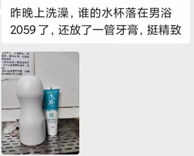 图片由上下两部分组成，上方为黑色文字的寻物通知，内容为“昨晚上洗澡，谁的水杯落在男浴2059了，还放了一管牙膏，挺精致”。下方是一张实拍照片，展示了一个白色圆柱形水杯和一管蓝白配色的牙膏并排放在浴室的金属网格置物架上，背景墙有模糊不清的规章制度文字。整体用于寻找遗落在男浴室2059号隔间的个人物品。