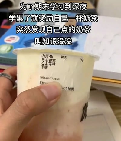 这是一张记录学生期末复习日常的实拍图片，画面中一只手拿着一杯标注“芝士莓莓”的奶茶，背景可见书本与纸张，营造出深夜学习的氛围。上方配文讲述了作者为应对期末熬夜学习，点奶茶犒劳自己时，发现“芝士莓莓”谐音“知识没没”，恰好戳中期末复习时担心知识记不住的焦虑心态，形成了有趣的谐音梗，充满搞笑与共鸣感。