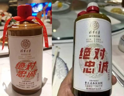 这是一张左右拼接的实拍图，展示了两款均标注“清华大学”、“仅限内部供应”的53度酱香型白酒：左侧为棕褐色瓶身，标注由贵州国马酒业（集团）有限公司出品、张云登大师谨酿；右侧为深绿色瓶身，标注由酱酒智造平台出品、曹文涛教授特调。两款酒瓶身标签都印有醒目的“绝对忠诚”红色字样，瓶身红丝带印有“合领传统佳酿 承文化经典”字样，拍摄场景为摆放着餐具的餐桌，推测是在私人聚餐场合拍摄。