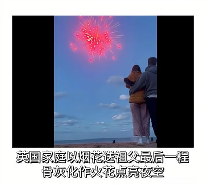 图片展示了一对男女站在海滩上，背对着镜头观看夜空中绽放的红色烟花。天空呈现出黄昏时分的蓝色，点缀着几朵白云，远处的海面上还有一个人独坐。图片下方配有文字说明：'英国家庭以烟花送祖父最后一程 骨灰化作火花点亮夜空'，讲述了一个英国家庭用烟花将祖父骨灰送上最后一程的故事，让逝者的骨灰化作夜空中的火花。