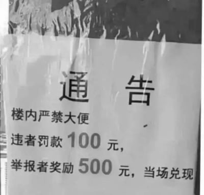 一张张贴在建筑物内的黑白通告照片，内容为“楼内严禁大便 违者罚款100元，举报者奖励500元，当场兑现”。通告以醒目的文字强调了禁止行为及相应的处罚与奖励措施，背景可能为建筑物内的墙面，整体给人严肃警示的感觉。