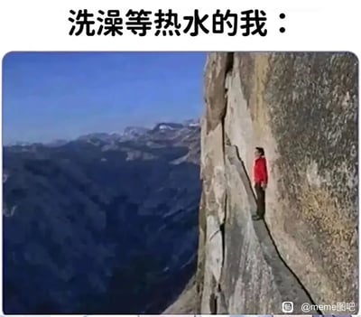 这是一张结合视觉错位效果的搞笑生活梗图，顶部配有文字“洗澡等热水的我：”，下方是一张利用拍摄角度制造视觉错觉的实景照片：一名穿红色上衣的人站在岩石的平面上，由于特殊的拍摄视角，看起来像是身处陡峭悬崖的狭窄缝隙中，给人一种惊险、忐忑的视觉感受。这张图用这种看似身处险境的视觉效果，生动比喻出人们在洗澡等待热水时的煎熬与忐忑心情——既盼着热水快点来，又担心水温突然出现冷热变化，那种纠结紧张的感觉如同站在悬崖边一般，精准戳中日常生活里的小痛点，充满诙谐感。