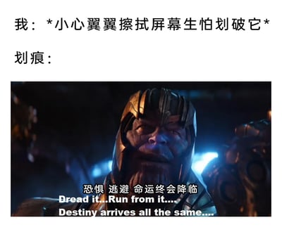 这是一张图文混排的搞笑网络梗图，上方以第一视角文字描述了数码产品使用者小心翼翼擦拭设备屏幕、极度担心出现划痕的日常状态；下方截取了漫威电影《复仇者联盟3：无限战争》中反派角色灭霸的经典场景，搭配灭霸的标志性台词“恐惧 逃避 命运终会降临”的中英双语字幕，将电子设备屏幕总会出现划痕的无奈现实，比作无法逃避的“命运”，用影视IP的经典内容来调侃日常数码使用中的小无奈，精准契合数码产品使用者的共鸣点，风格幽默接地气。