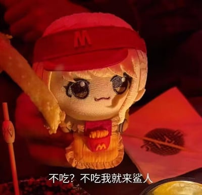 图片中展示了一个麦当劳主题的玩偶，它戴着红色帽子，帽子上有一个明显的"M"标志。玩偶有着大大的眼睛和金色的头发，穿着带有麦当劳标志的衣服。它的一只手向上举起，似乎拿着一根薯条。图片底部有一行中文文字："不吃? 不吃我就来鲨人"，意思是"不吃饭吗？不吃饭我就来杀人"，这是一种夸张幽默的表达方式。整体画面采用暗色调背景，突出显示玩偶主体，营造出一种反差萌的搞笑效果。