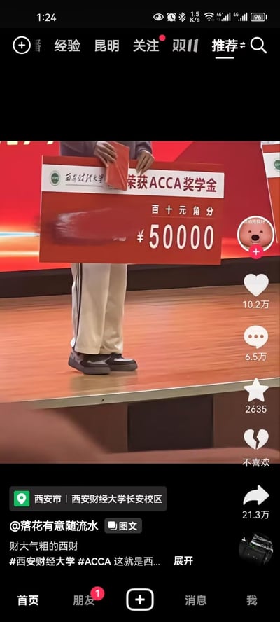 这是一张抖音平台的竖屏视频截图，展示了西安财经大学长安校区的颁奖现场：一名学生站在舞台上，手持写有“西安财经大学 荣获ACCA奖学金 ¥50000”的大额奖金牌，奖金金额为50000元整。该视频在抖音获得10.2万点赞、6.5万评论与21.3万转发，配文“财大气粗的西财”，引发网友对高校高额奖学金的关注与讨论，图中无谐音梗、双关或暗示内容。