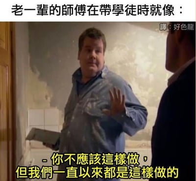 图片展示了一位穿着沾有涂料的蓝色衬衫的工人，正在对另一个人说话。上方文字写着'老一辈的师傅在带学徒时就像：'，下方黄色文字写着'- 你不应该这样做，但我们一直以来都是这样做的'。这张图通过幽默的方式讽刺了某些传统工作场所中，老师傅虽然指出做法不对，却坚持沿用传统方式的矛盾现象。